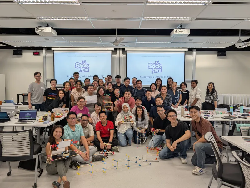 An SUTD teacher cohort seated with the structures they built