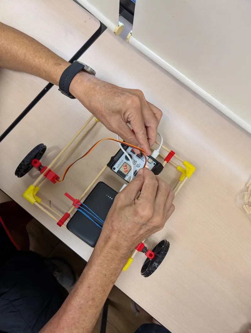 Plugging in the power bank to bring a chopstick car to life