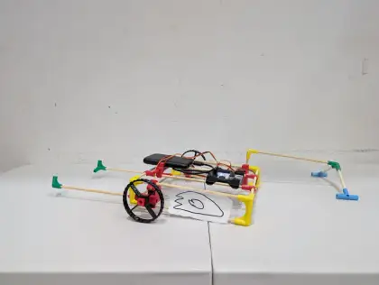 A sideways cart with a drawn face and long arm