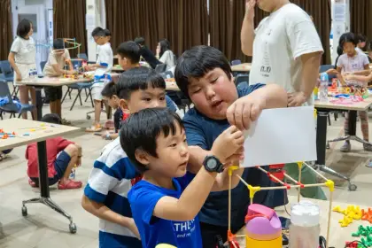 Helping two children connect their first sticks