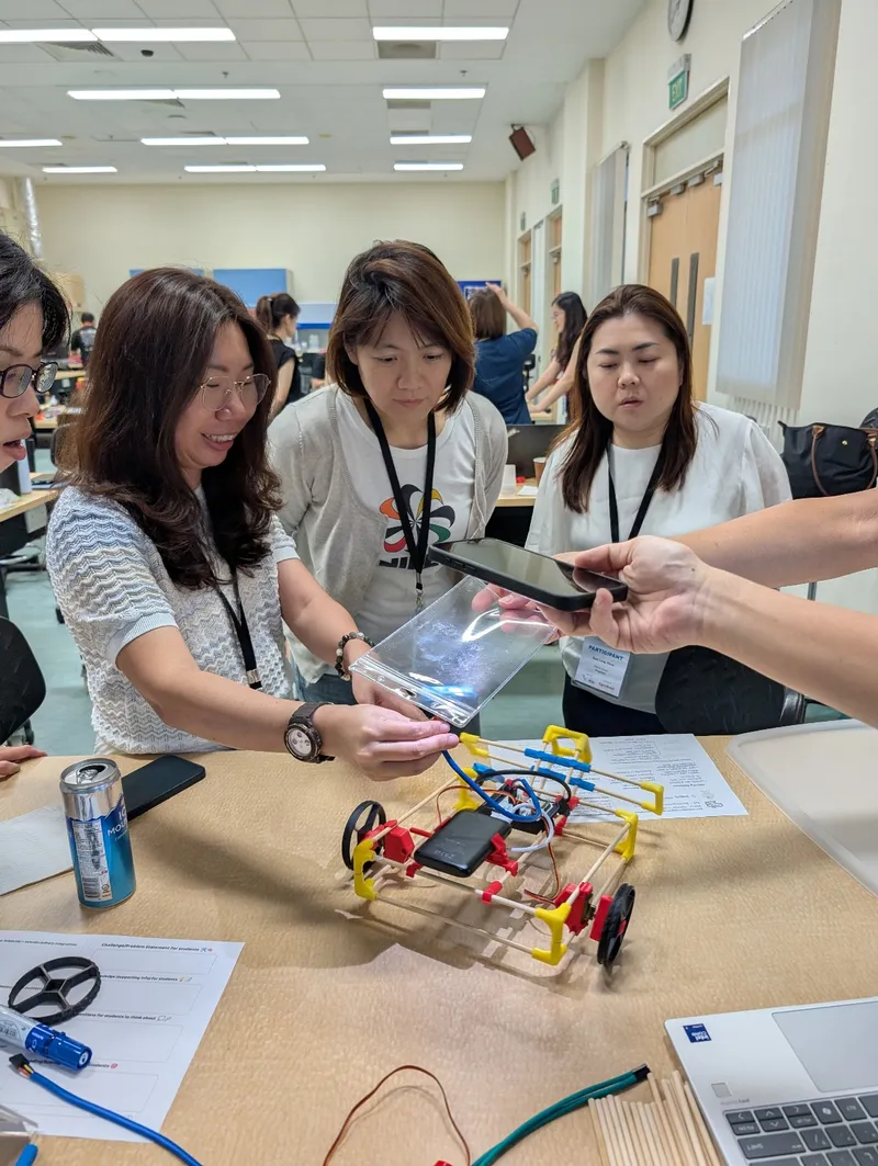 Teachers wiring up a Stick ’Em car and filming it on a phone